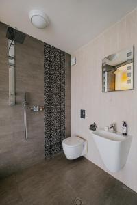 ein Bad mit einem Waschbecken, einem WC und einer Dusche in der Unterkunft Miletia Suites in Sozopol