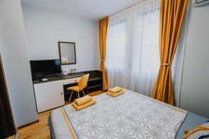 Schlafzimmer mit einem Bett, einem Schreibtisch und einem TV in der Unterkunft Miletia Suites in Sozopol