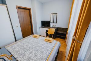 ein kleines Schlafzimmer mit einem Bett und einem Schreibtisch in der Unterkunft Miletia Suites in Sozopol