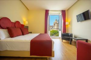 a hotel room with a bed and a view of the city at Hotel Florida in San Lorenzo de El Escorial