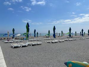 a group of lounge chairs and umbrellas on a beach at Vila Plaja Azur in Eforie Nord