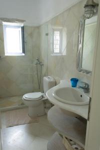 een witte badkamer met een wastafel en een toilet bij Kalma villa in Santa Maria