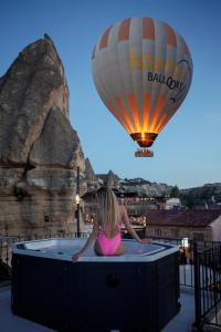 Eine Frau im Bikini, die in einem Heißluftballon sitzt. in der Unterkunft The Niche Cave Hotel in Goreme
