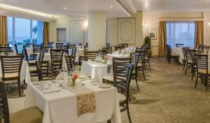 a banquet room with white tables and chairs at Southern Sun The Marine in Port Elizabeth