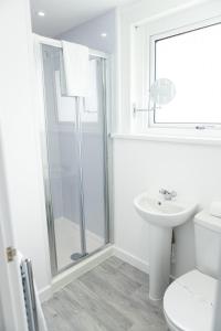 uma casa de banho com um chuveiro, um WC e um lavatório. em Fred's Place em Plymouth