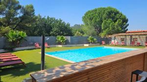 a swimming pool in a yard with a wooden fence at Best Western Terre de Provence in Le Cannet-des-Maures