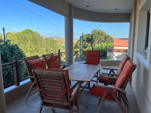 a porch with a wooden table and chairs on a balcony at Ornela's Home in Yiánnidhes