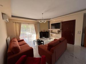 a living room with two brown couches and a television at Ornela's Home 