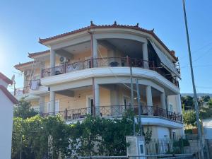 a large white building with balconies on top of it at Ornela's Home in Yiánnidhes