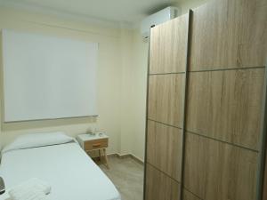 a bedroom with a bed and a wooden cabinet at Delicia, Sol y mar in Málaga
