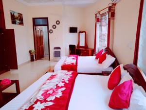 una camera con due letti con lenzuola rosse e bianche di Renajoe Exclusive Centre 