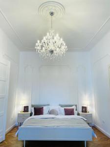 a bedroom with a large bed with a chandelier at LittleParis in Cluj-Napoca