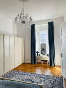 a living room with a chandelier and blue curtains at LittleParis in Cluj-Napoca