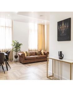 ein Wohnzimmer mit einem Sofa und einem Tisch in der Unterkunft The Pocklington - The Bradgate Suite in Leicester