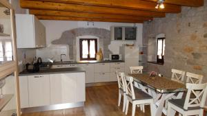 Casa vacanze - alloggio agrituristico Col في Monrupino: مطبخ وغرفة طعام مع طاولة وكراسي