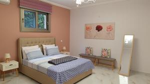 1 dormitorio con 1 cama, 2 mesas y espejo en Ebony and Ivory Suites, en Drosiá