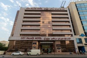 a building with cars parked in front of it at City Palace Hotel in Dubai