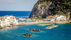 a view of a beach with buildings and the ocean at Neruda Chic House Sant'Angelo in Sant'Angelo D'Ischia