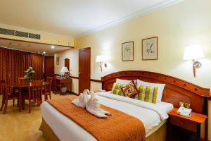 a hotel room with a bed and a dining room at City Palace Hotel in Dubai