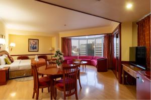 a hotel room with a bed and a dining room at City Palace Hotel in Dubai