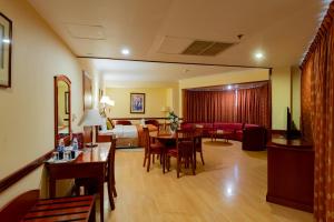a hotel room with a bedroom and a living room at City Palace Hotel in Dubai