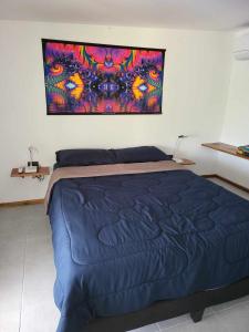 Un dormitorio con una cama azul con una pintura en la pared en Lost paradise 2 en Hinkong