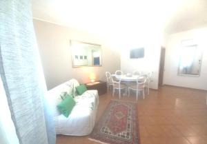 ein Wohnzimmer mit einem weißen Sofa und einem Tisch in der Unterkunft Etrusca shabby chic apartment - Tuscany - Venturina Terme in Venturina Terme