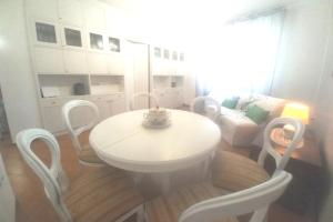 einen weißen Tisch und Stühle im Wohnzimmer in der Unterkunft Etrusca shabby chic apartment - Tuscany - Venturina Terme in Venturina Terme
