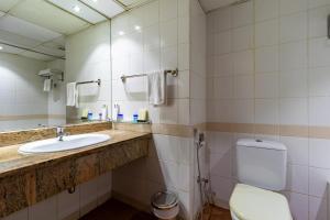 a bathroom with a sink and a toilet and a mirror at City Palace Hotel in Dubai