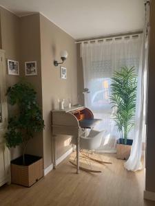 Cardedeu Circuit apartment في كارديديو: غرفة بها مكتب ونافذة بها نباتات