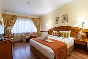 a hotel room with a large bed and a television at City Palace Hotel in Dubai