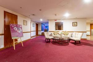 a waiting room with a table and chairs and a sign at City Palace Hotel in Dubai