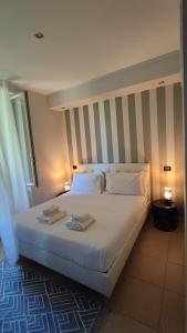 a bedroom with a white bed with two towels on it at Il Roseto in Frosinone