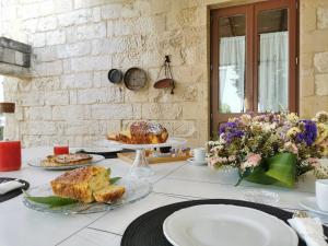 een tafel met eten en borden met voedsel erop bij Don Agostino Relais Masseria in Martano