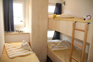 ein Zimmer mit einem Etagenbett, 2 Etagenbetten und einem Fenster in der Unterkunft Offizier 15 in Neustadt in Holstein