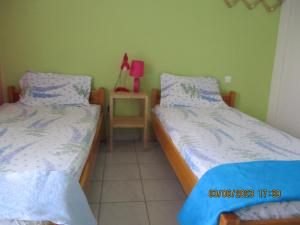 a bedroom with two beds and a table with a lamp at Anna's Sweet Home Akrata in Paralía Akrátas