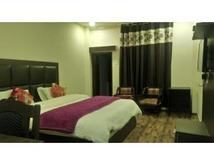 1 dormitorio con 1 cama grande y 1 silla en Shining Star Resort, Khajjiar, en Khajjiar 