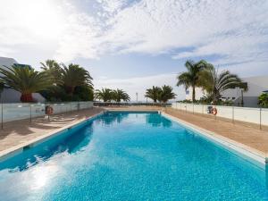 basen z błękitną wodą i palmami w obiekcie Villa Suculenta w mieście Playa Blanca