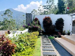 um jardim com algumas plantas e uma parede branca em Skyline BlueDome Villa Ciwidey em Ciwidey