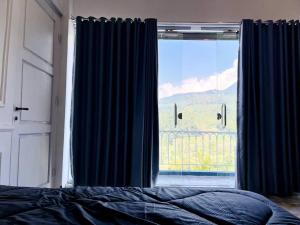 a bedroom with a bed and a large window at Skyline BlueDome Villa Ciwidey in Ciwidey