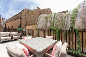patio ze stołem, krzesłami i ogrodzeniem w obiekcie Grosvenor Mayfair w Londynie
