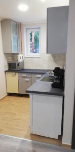 Una cocina con gabinetes blancos y encimera. en Napolá apartman, en Balatonalmádi 3 fotos más
