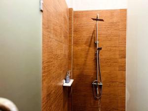 a shower in a bathroom with a wooden wall at Skyline BlueDome Villa Ciwidey in Ciwidey +52 photos