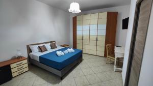 a bedroom with a bed with a blue comforter at Helianthus Rooms in Lecce +16 photos