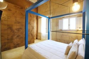 een slaapkamer met een bed met een blauw frame bij Don Agostino Relais Masseria in Martano