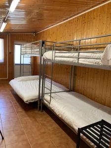 two bunk beds in a room with wooden walls at Albergue Naturmaz in Mazaricos