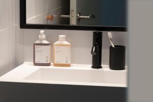a bathroom sink with two bottles of soap and a toothbrush at TOC Hotel Las Ramblas in Barcelona