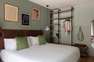 a bedroom with a large white bed with green pillows at TOC Hotel Las Ramblas in Barcelona