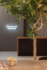 a tree sitting on a table next to a coffee cup at TOC Hotel Las Ramblas in Barcelona