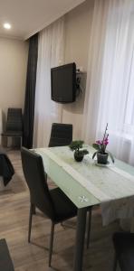 mesa con sillas y TV en una habitación en Napolá apartman, en Balatonalmádi